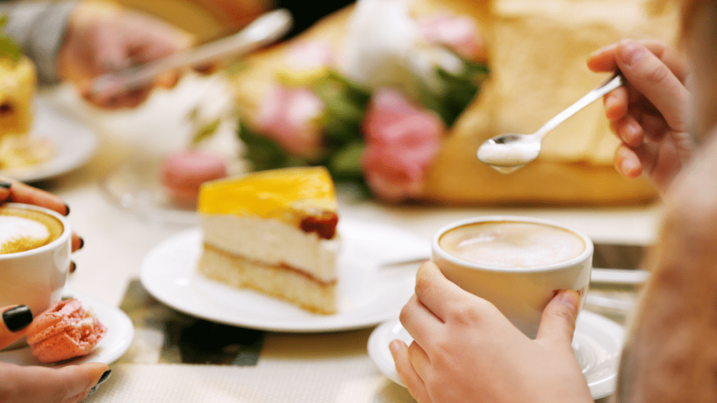 Pessoas sentadas à mesa tomando café da manhã com bolos caseiros
