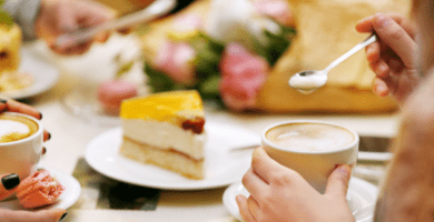 Pessoas sentadas à mesa tomando café da manhã com bolos caseiros