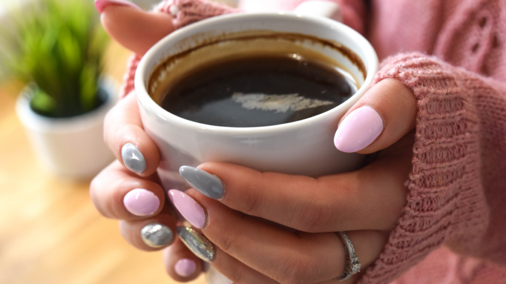 mãos femininas segurando xícara de café para ilustrar o post sobre como tomar café sem açucar