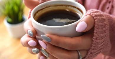 mãos femininas segurando xícara de café para ilustrar o post sobre como tomar café sem açucar