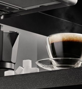 xícara de café ao lado de uma cafeteira italiana