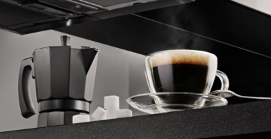 xícara de café ao lado de uma cafeteira italiana