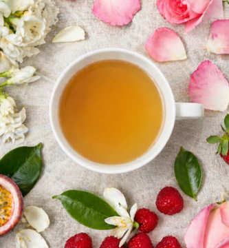 Xícara de café etíope especial rodeada de flores de jasmim, framboesas e frutas frescas representando as notas florais e frutadas no café