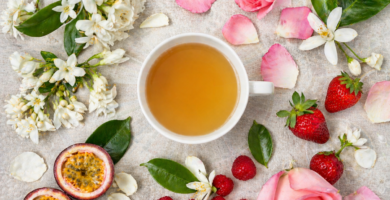 Xícara de café etíope especial rodeada de flores de jasmim, framboesas e frutas frescas representando as notas florais e frutadas no café