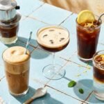 Cafés gelados de vários países sobre mesa azul: vietnamita, frappé, shakerato, mazagran e espresso tônica