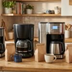 Cafeteiras elétricas de filtro com jarra de vidro e de inox lado a lado na bancada